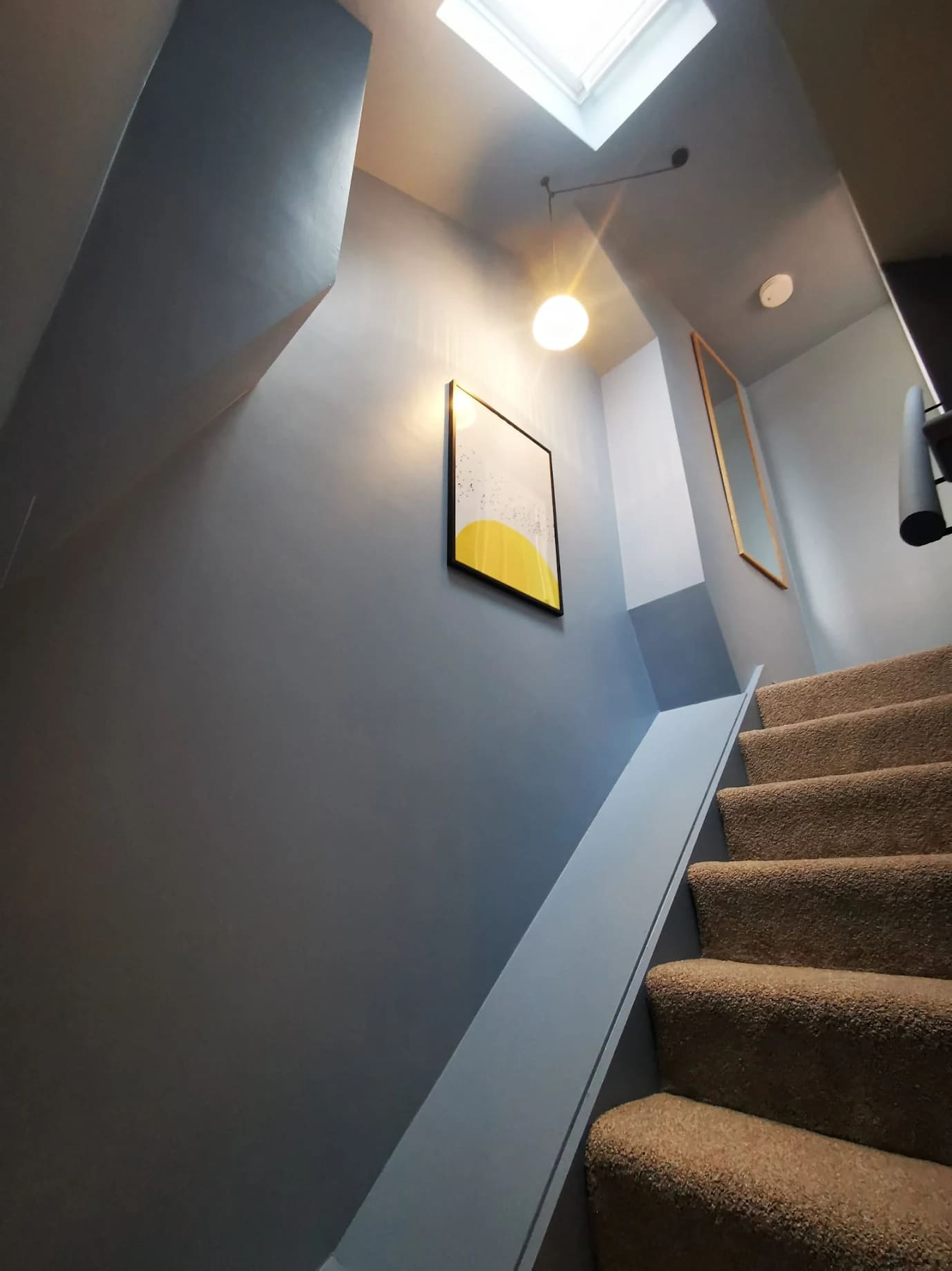 Completed loft staircase with painted walls, skylight and carpeted steps