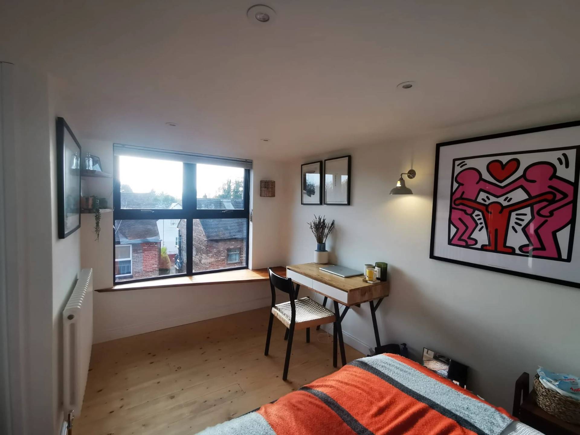 Finished loft bedroom with desk, window seat and framed artwork