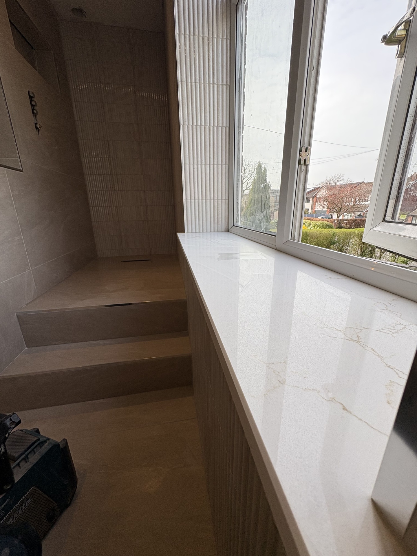Completed bathroom or wet room detail with premium stone-effect finishes