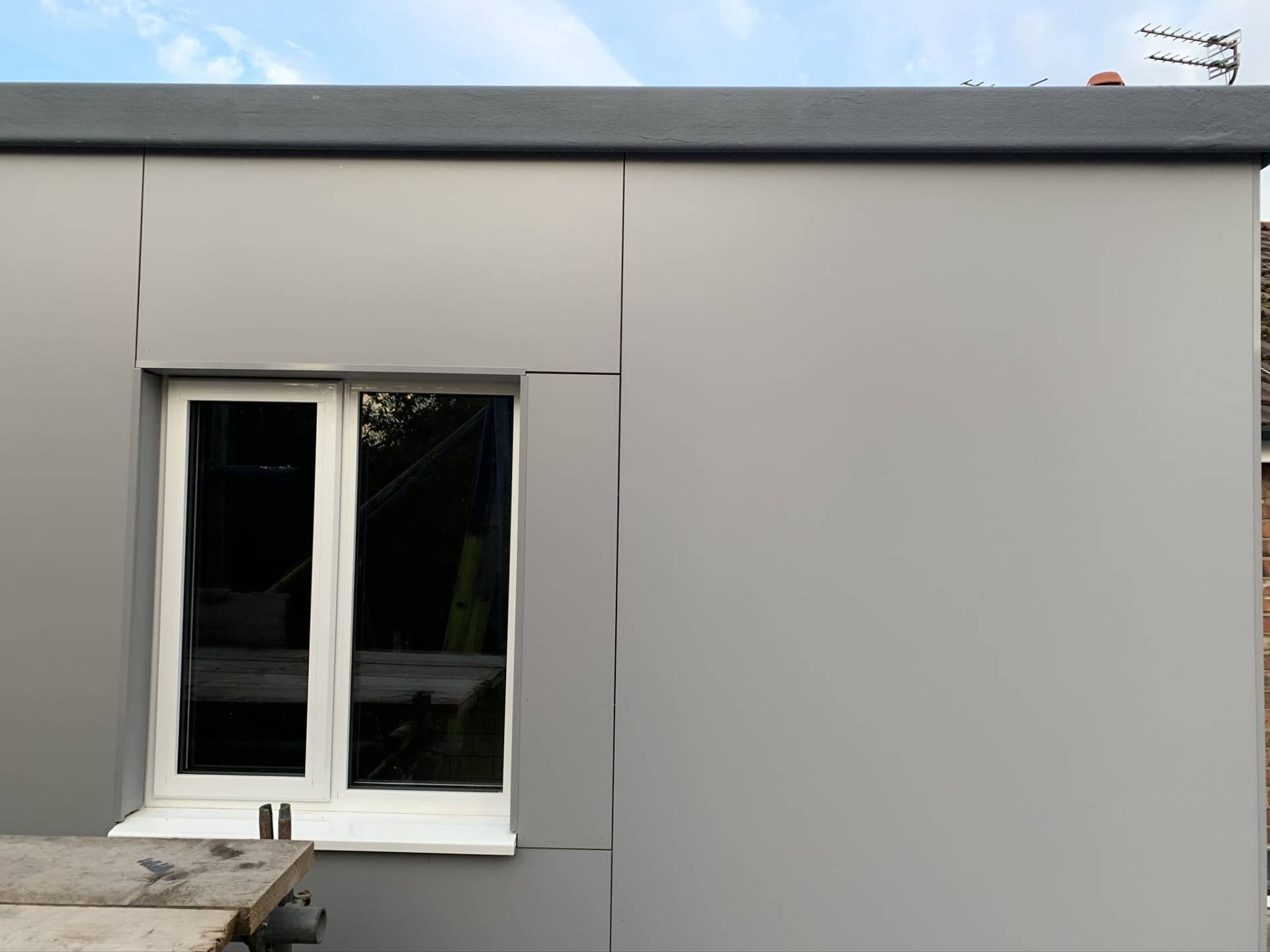 Completed grey-clad extension elevation with crisp window reveal details