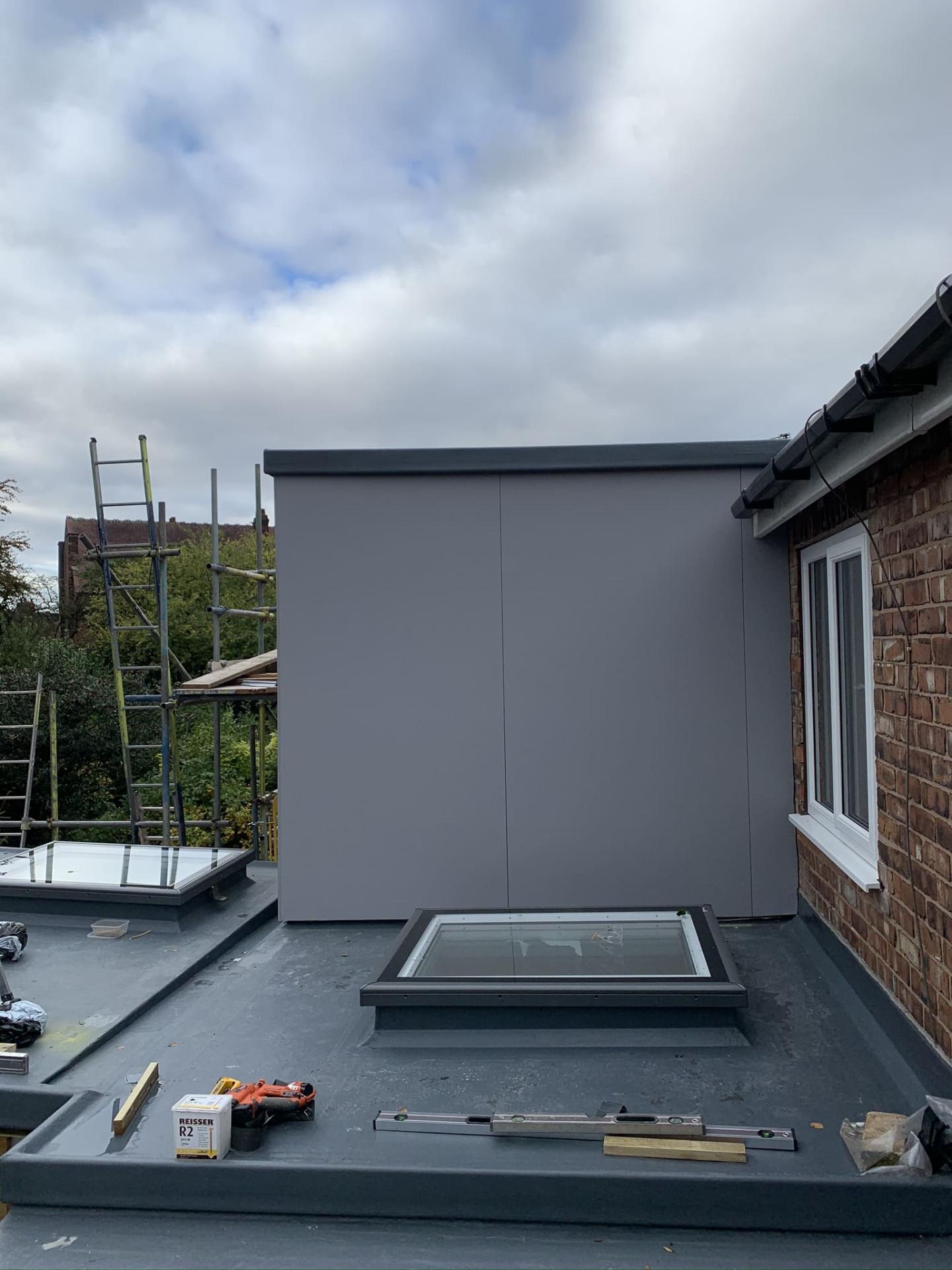 Completed flat-roof extension with rooflight and minimalist grey cladding