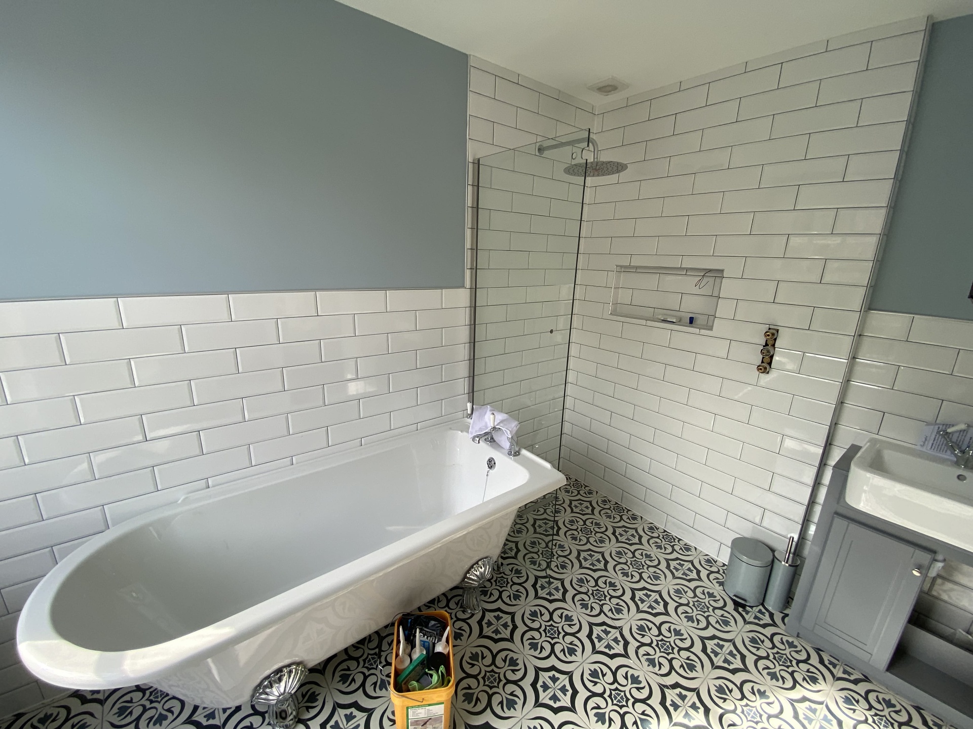 Completed bathroom with freestanding bath, wall tiling and patterned floor