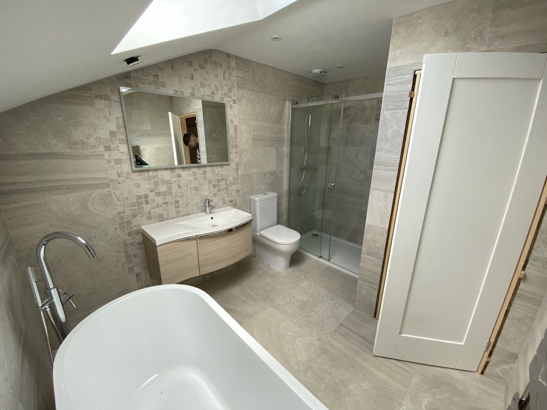Completed freestanding bath installation with tiled surround