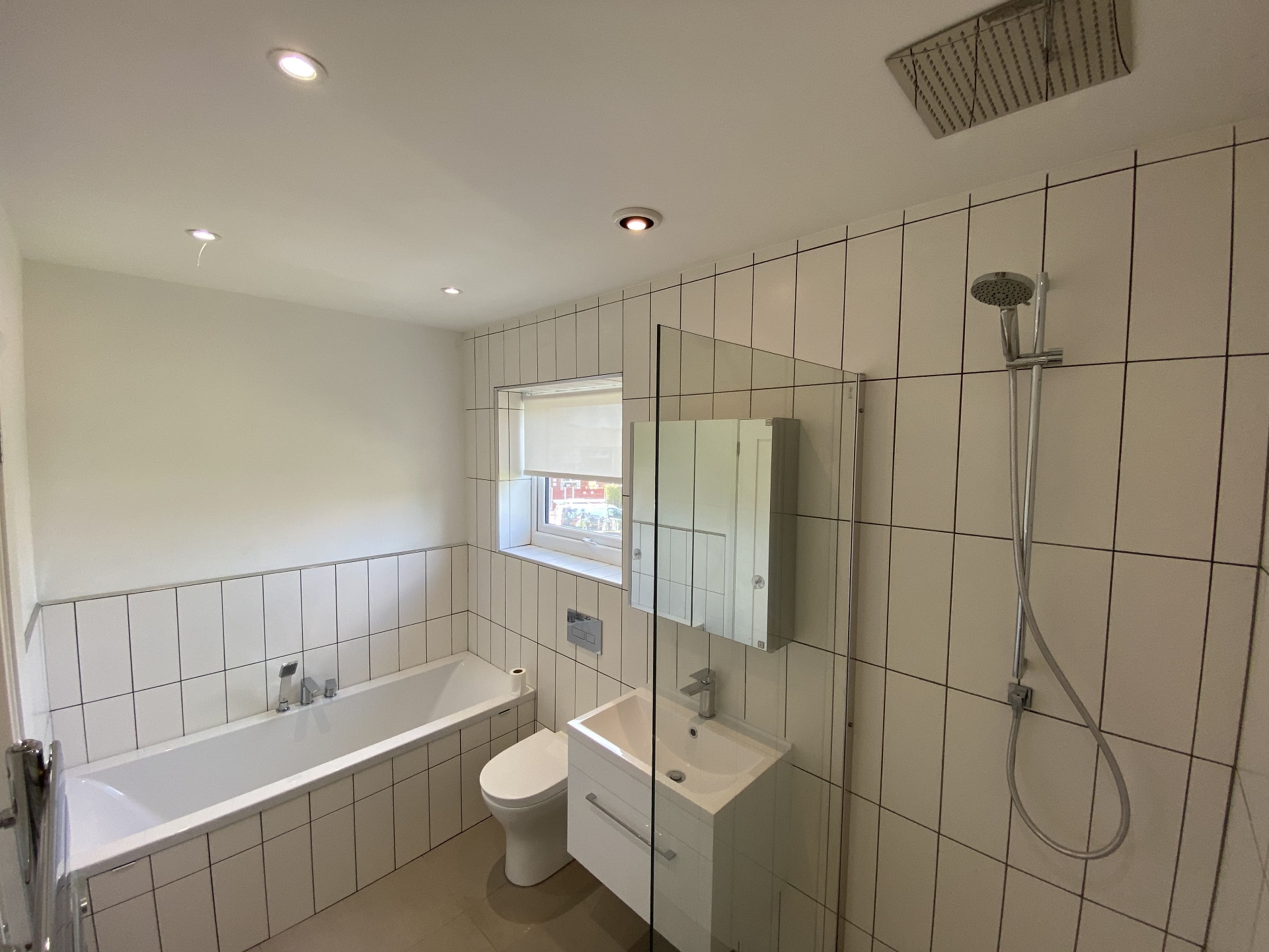 Completed shower room with white tiled walls and patterned flooring