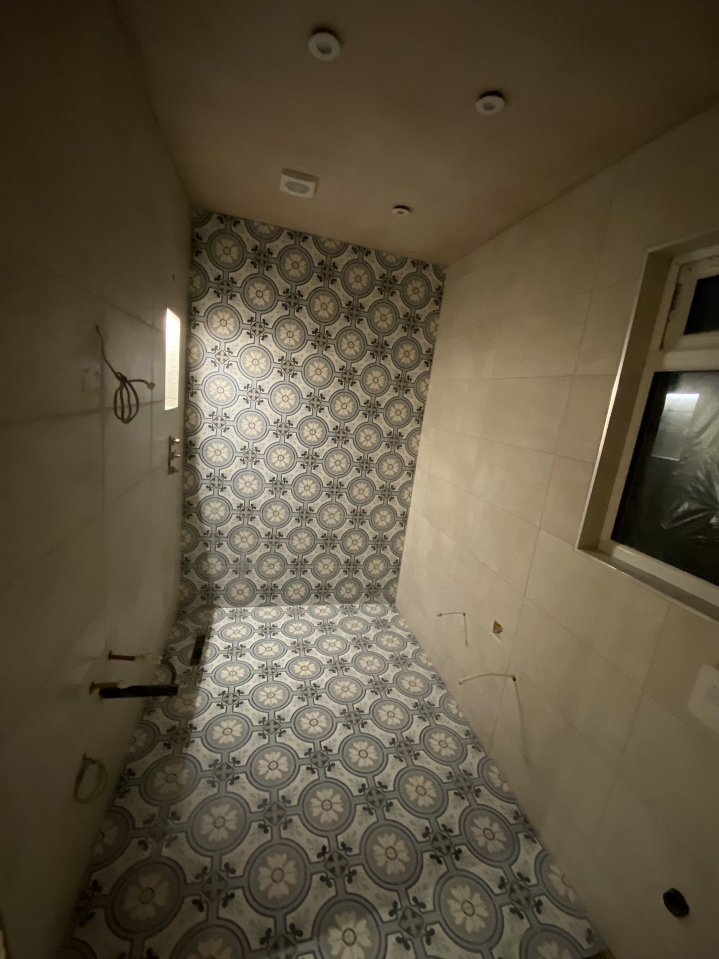 Completed shower room with patterned floor tiles and glazed enclosure