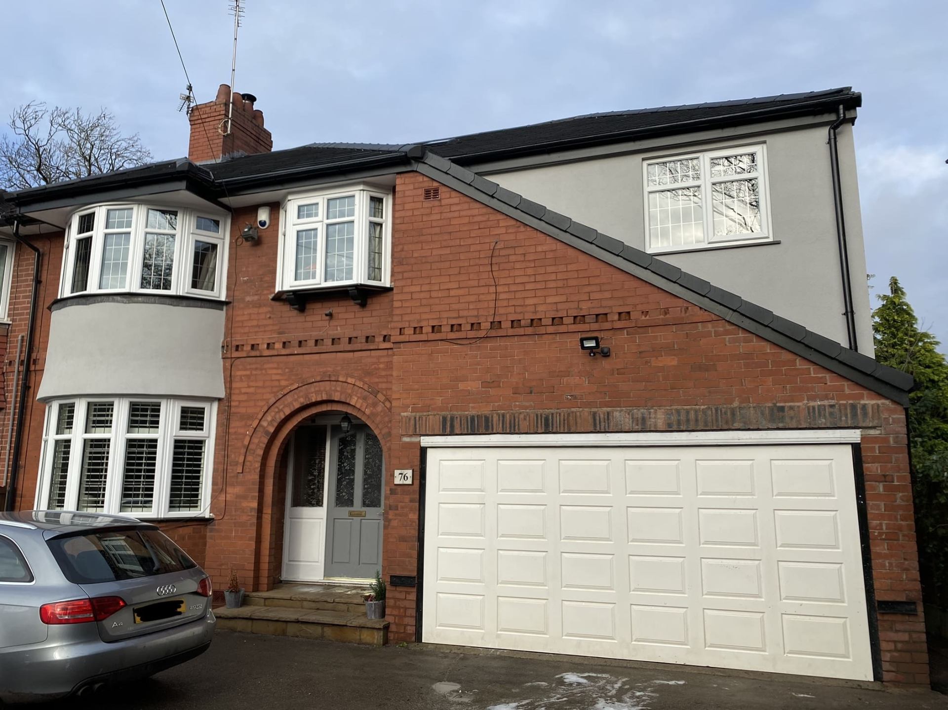 Completed front elevation of a two-story brick home with white garage door and pristine frontage