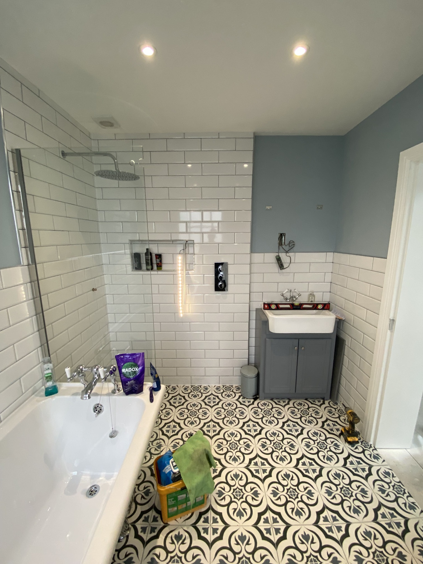 Completed bathroom with walk-in shower, two-tone walls and patterned encaustic floor tiles