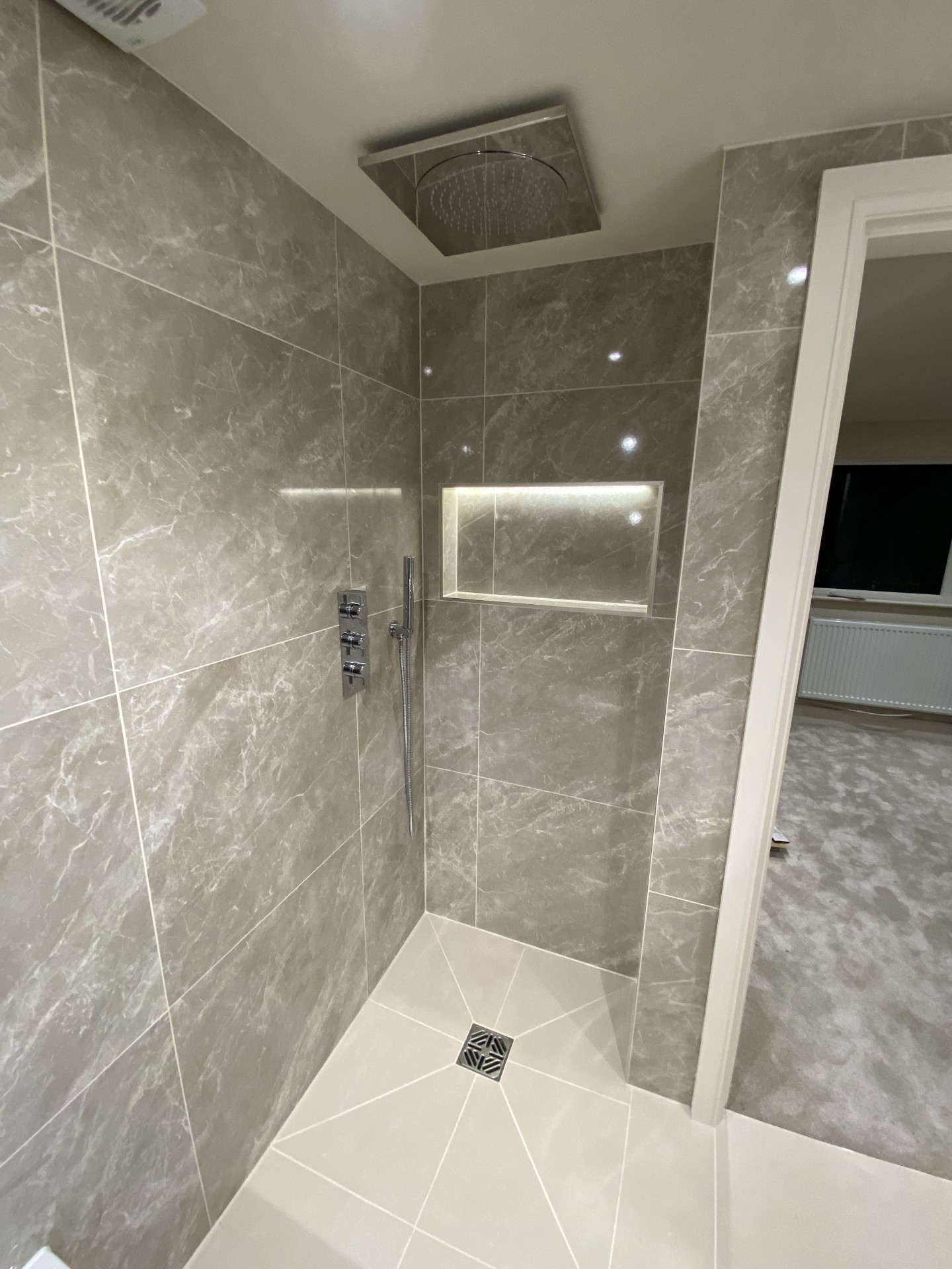 Completed bathroom with vanity unit, WC and patterned floor tiles