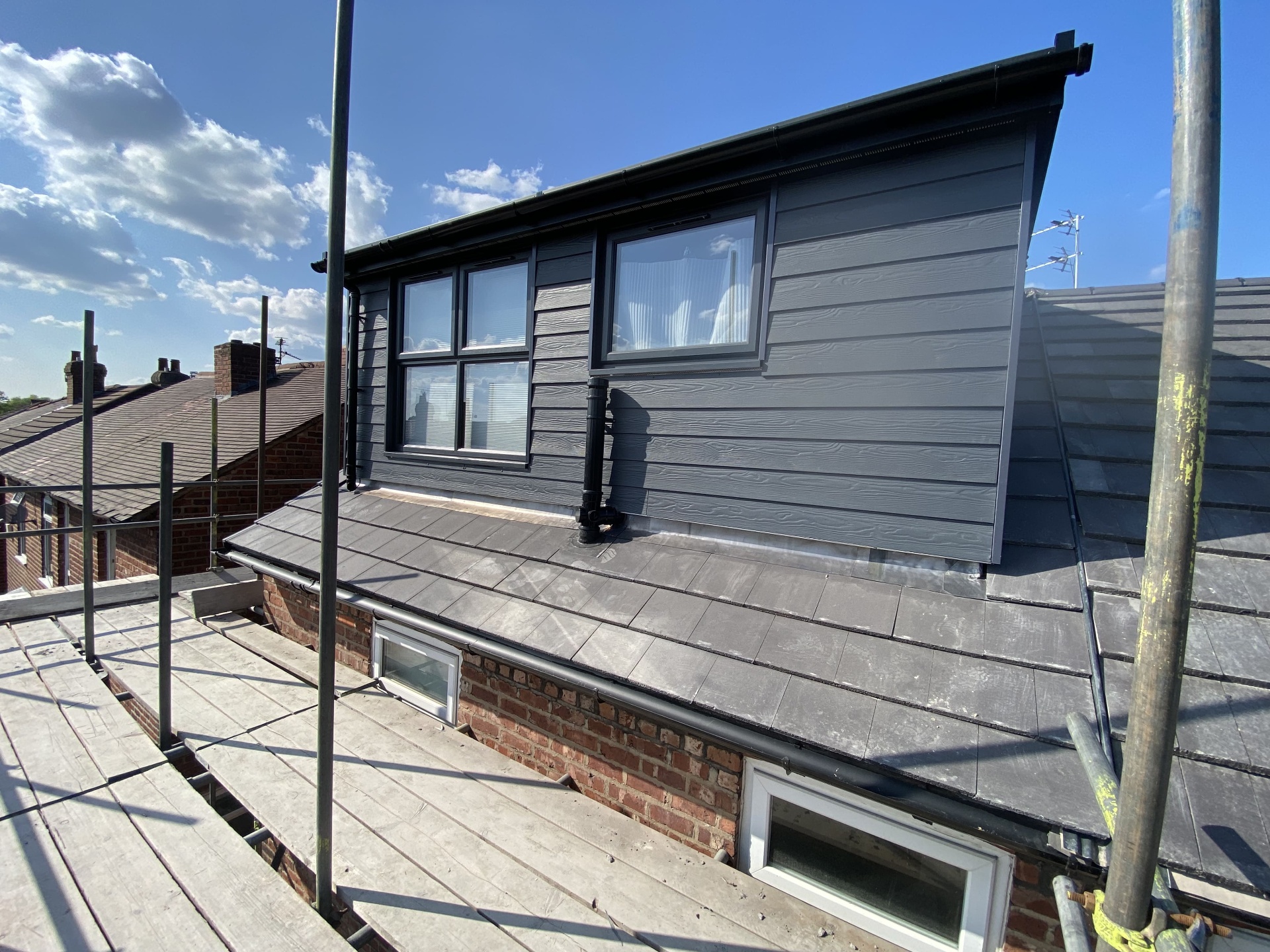 Completed dormer exterior with dark cladding, new windows and roofline detailing