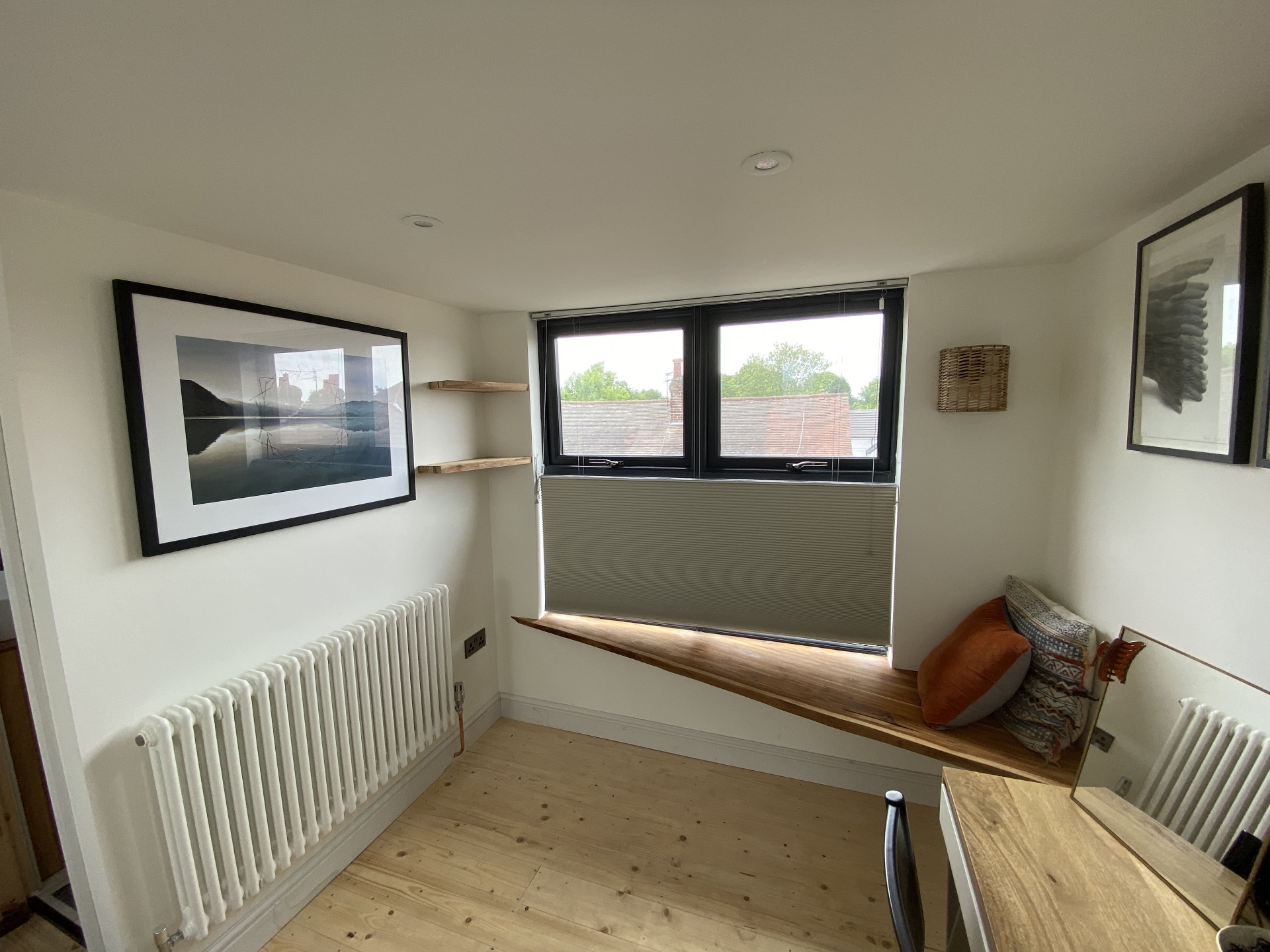 Finished loft room with built-in window seat, desk and shelving