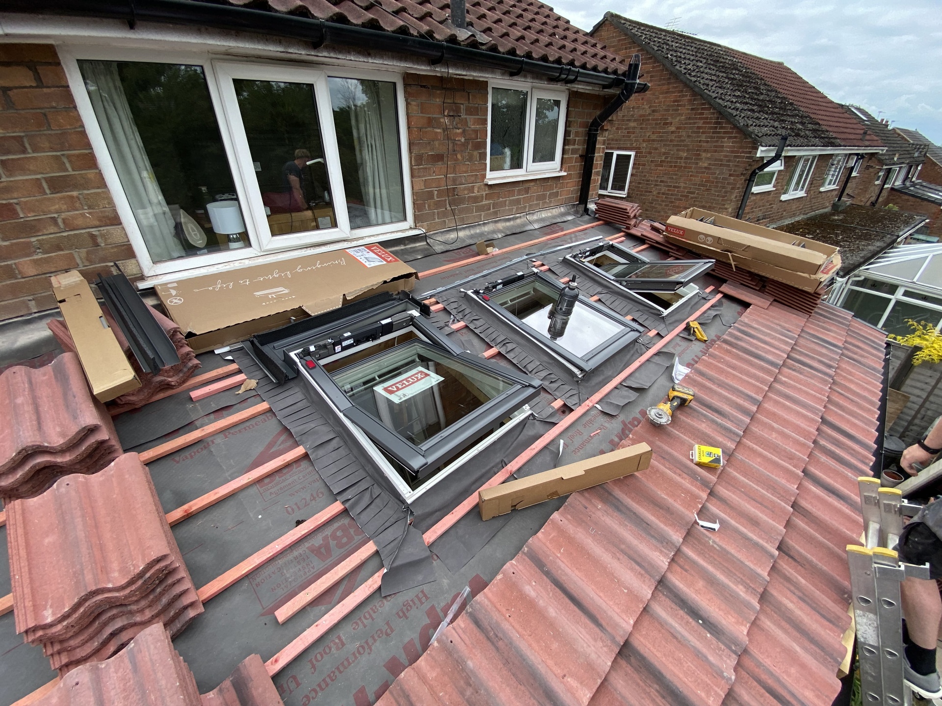 Rooflight installation underway on a tiled roof during loft works