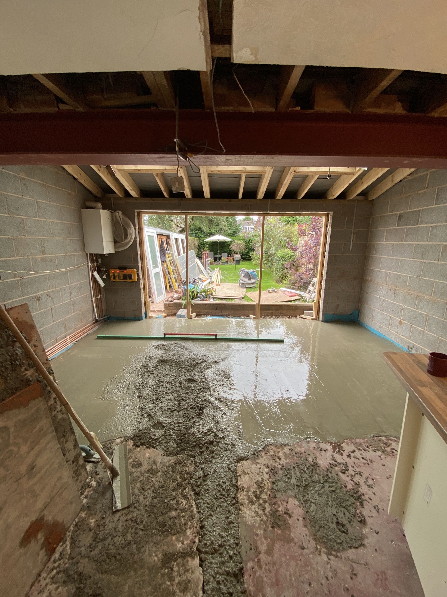 Freshly poured slab inside an extension shell before internal fit-out