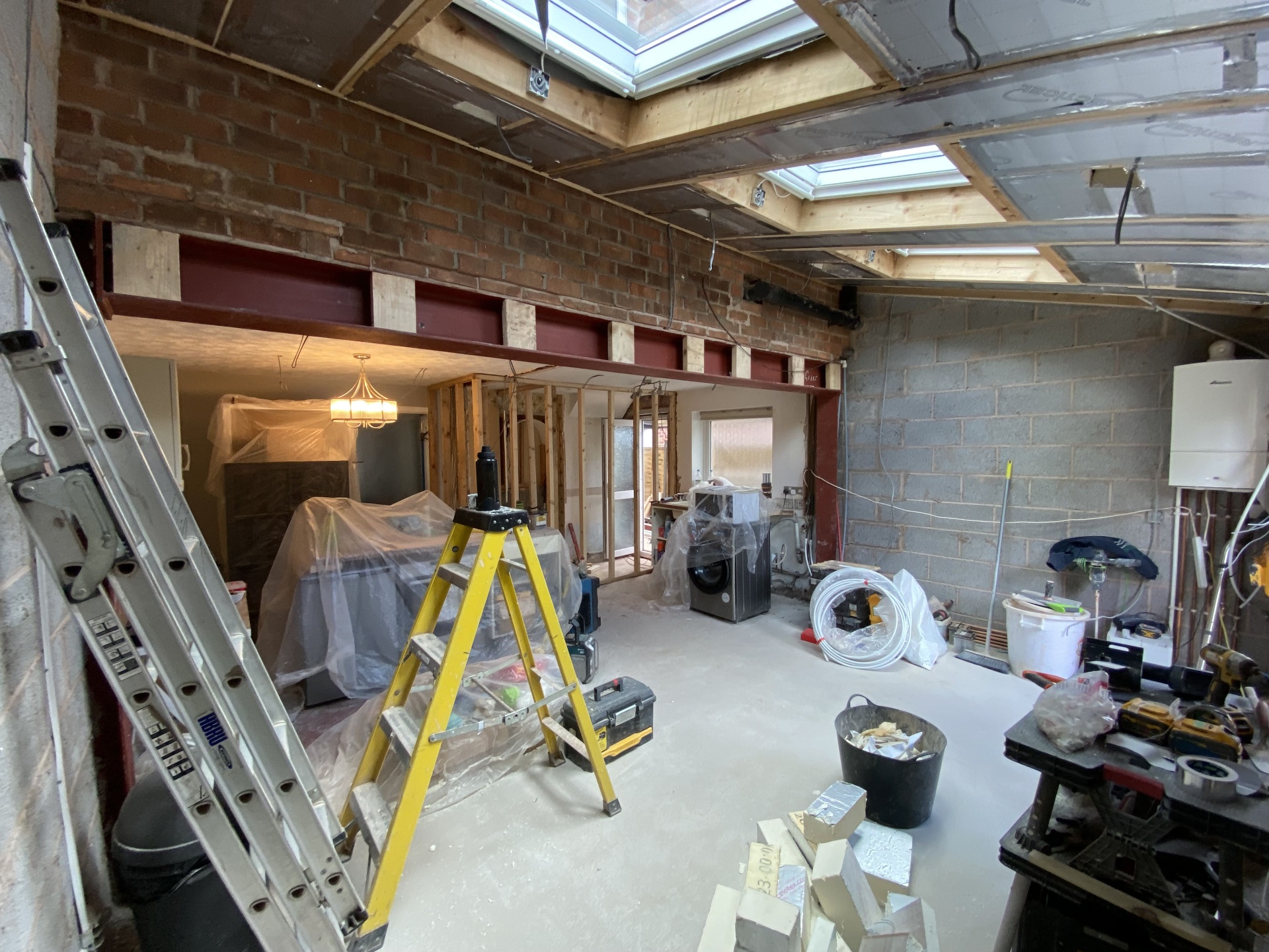 Rear extension interior under construction with rooflights, steels and first-fix progress
