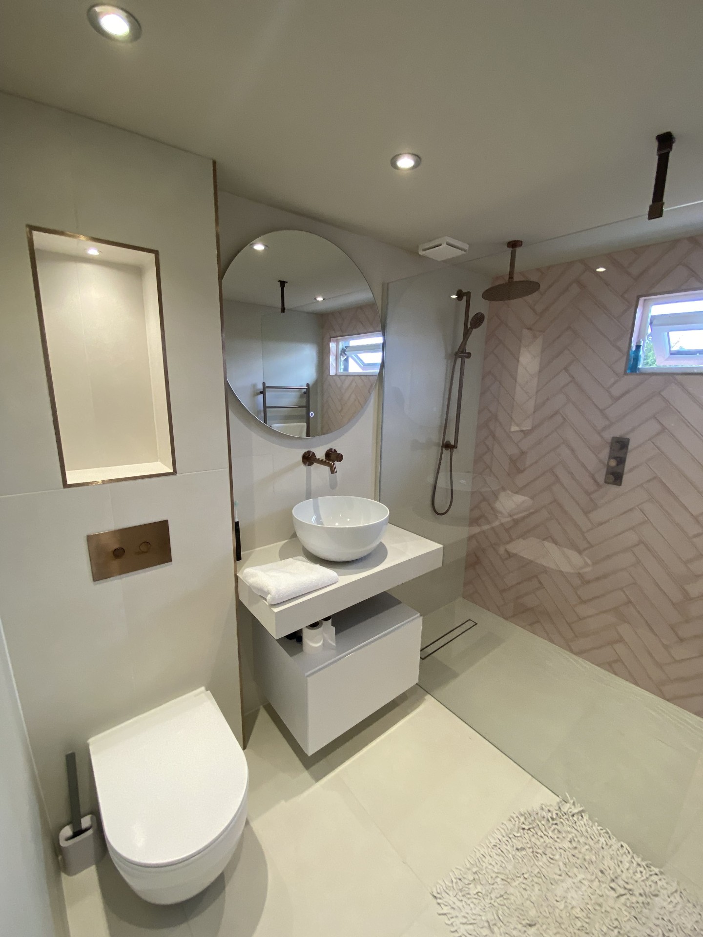 Completed bathroom with shower enclosure and stone-effect tiling
