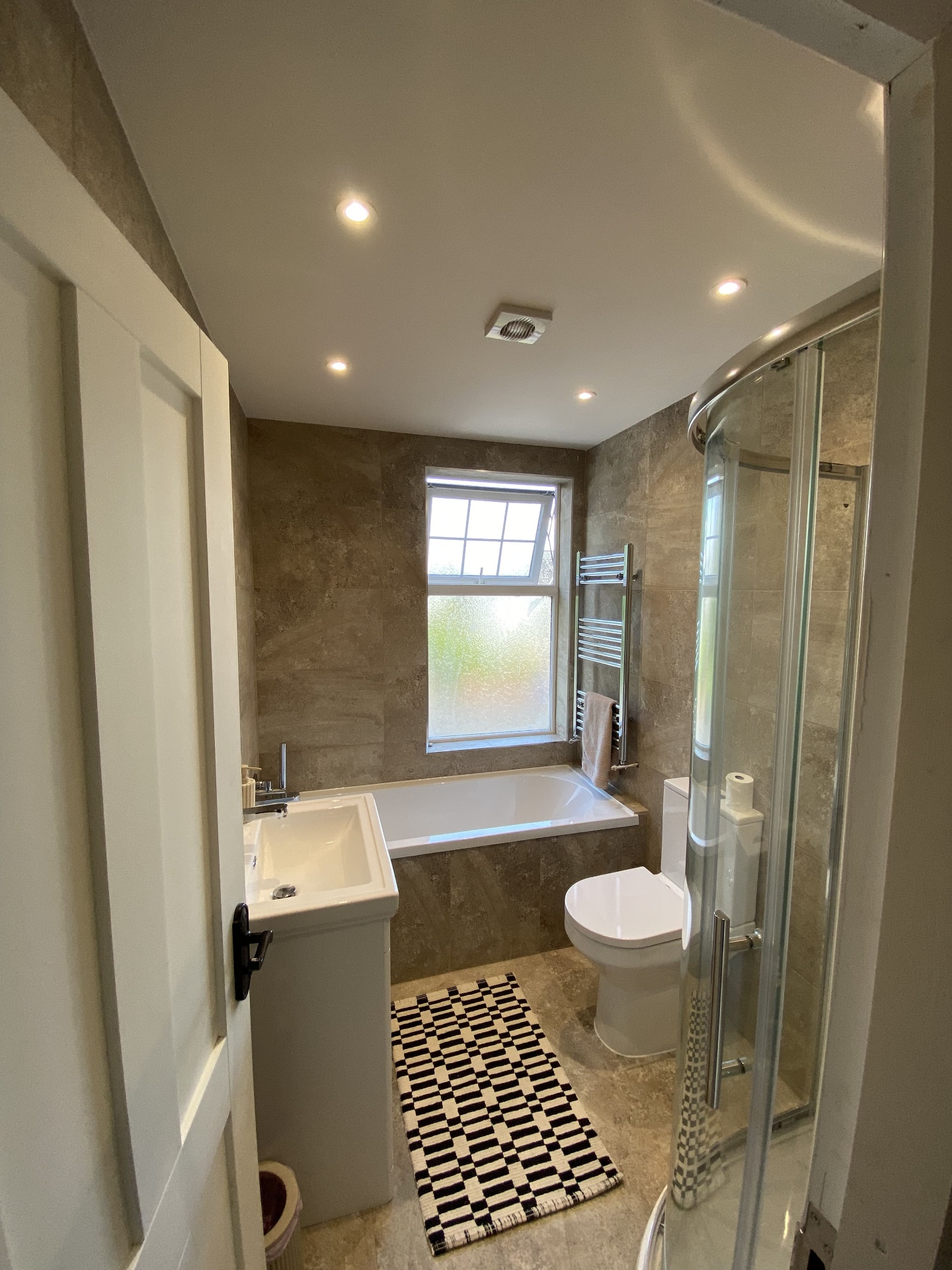 Completed bathroom with premium tiling, sanitaryware and ceiling spotlights