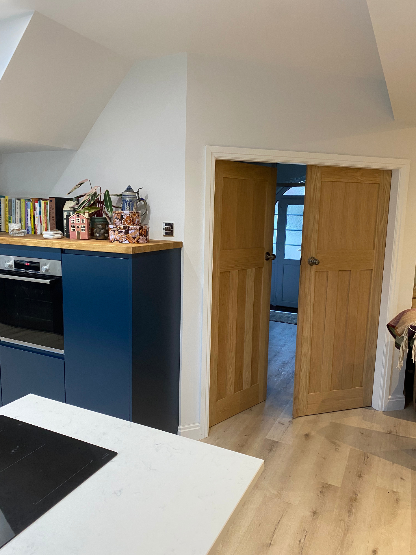 Kitchen cabinetry and oak pocket doors installed as part of a completed renovation