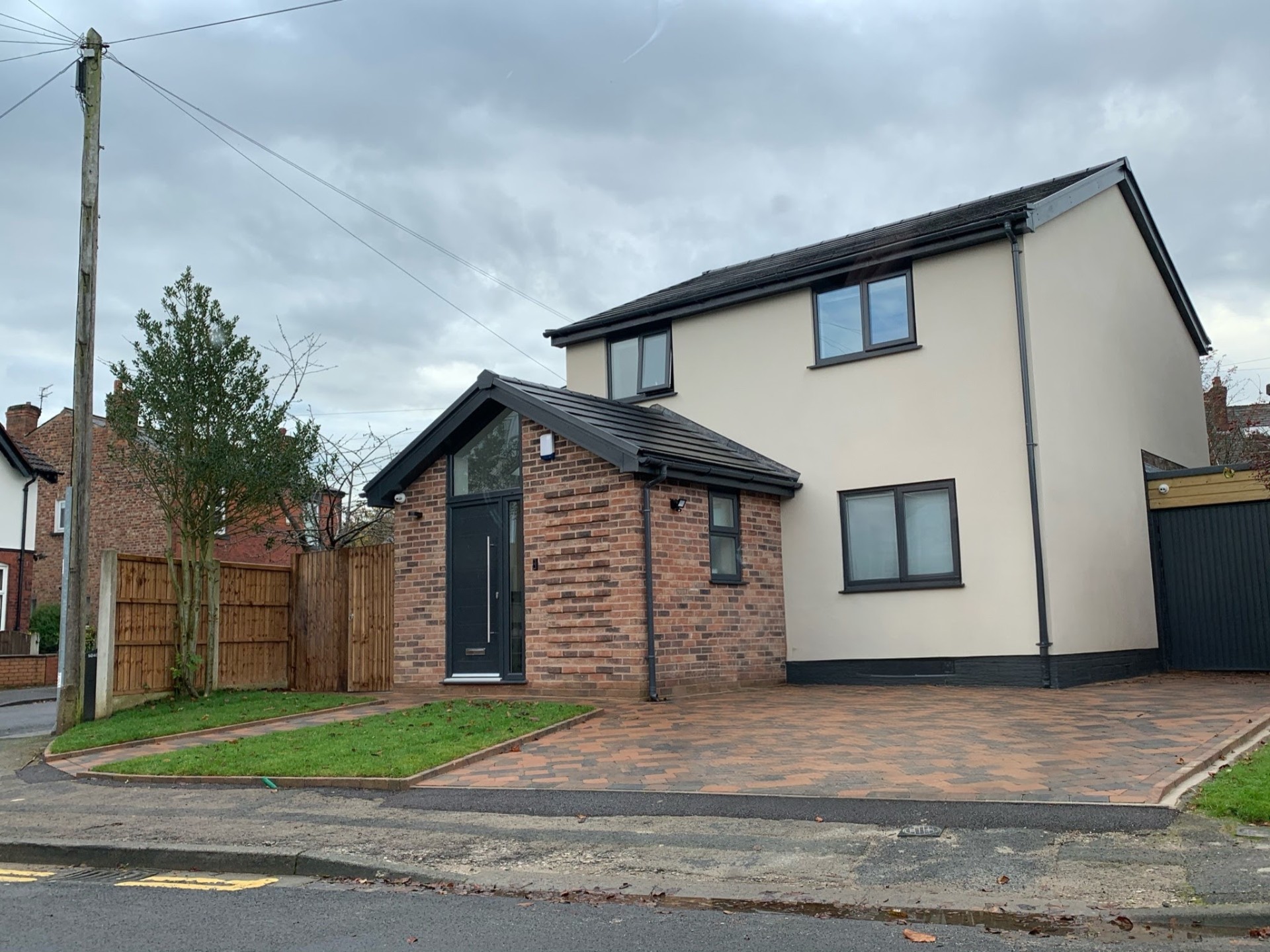 Completed detached home with new front porch extension, render finish and block-paved driveway in Stockport