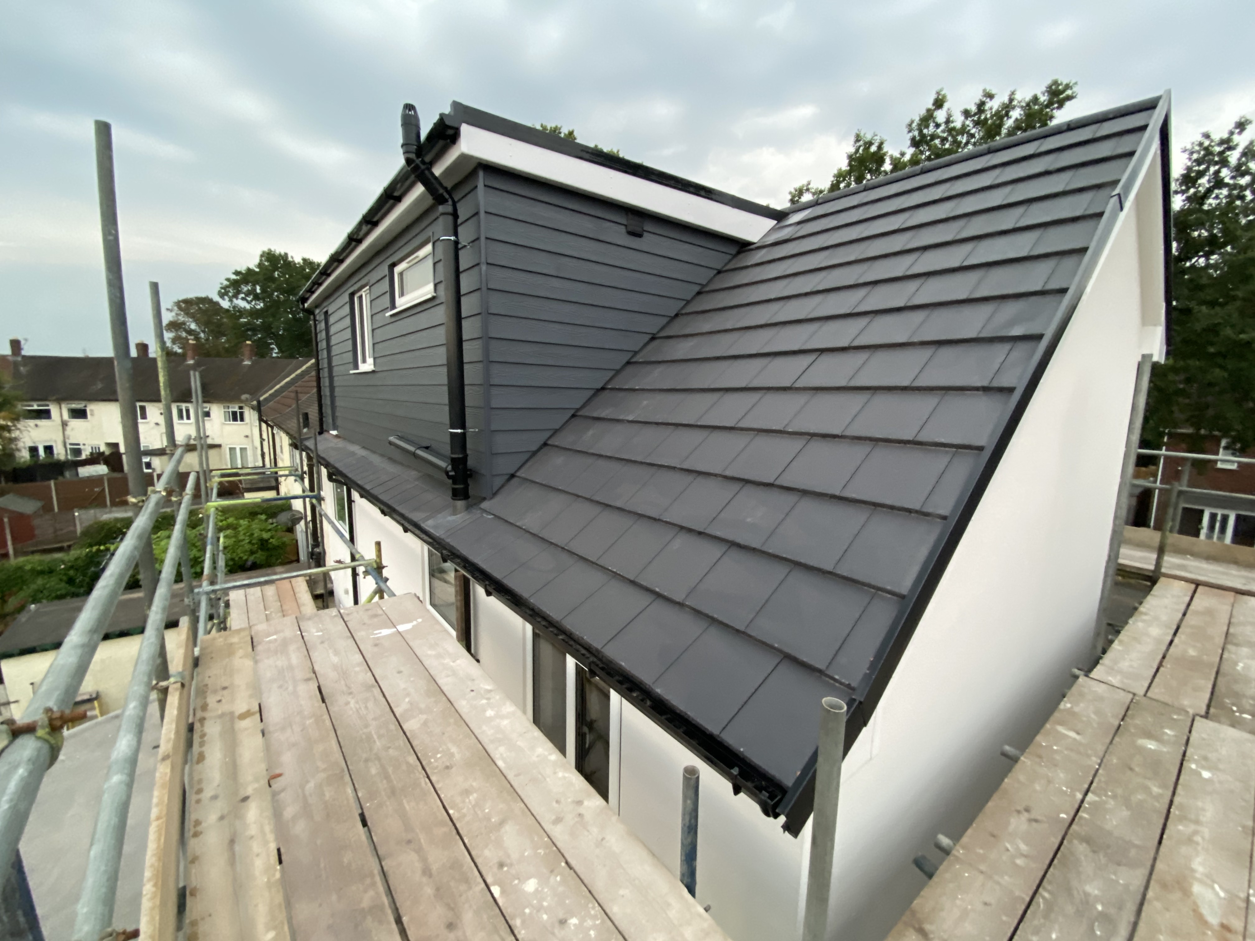 Finished dormer loft conversion exterior with grey cladding and new tiled pitched roof